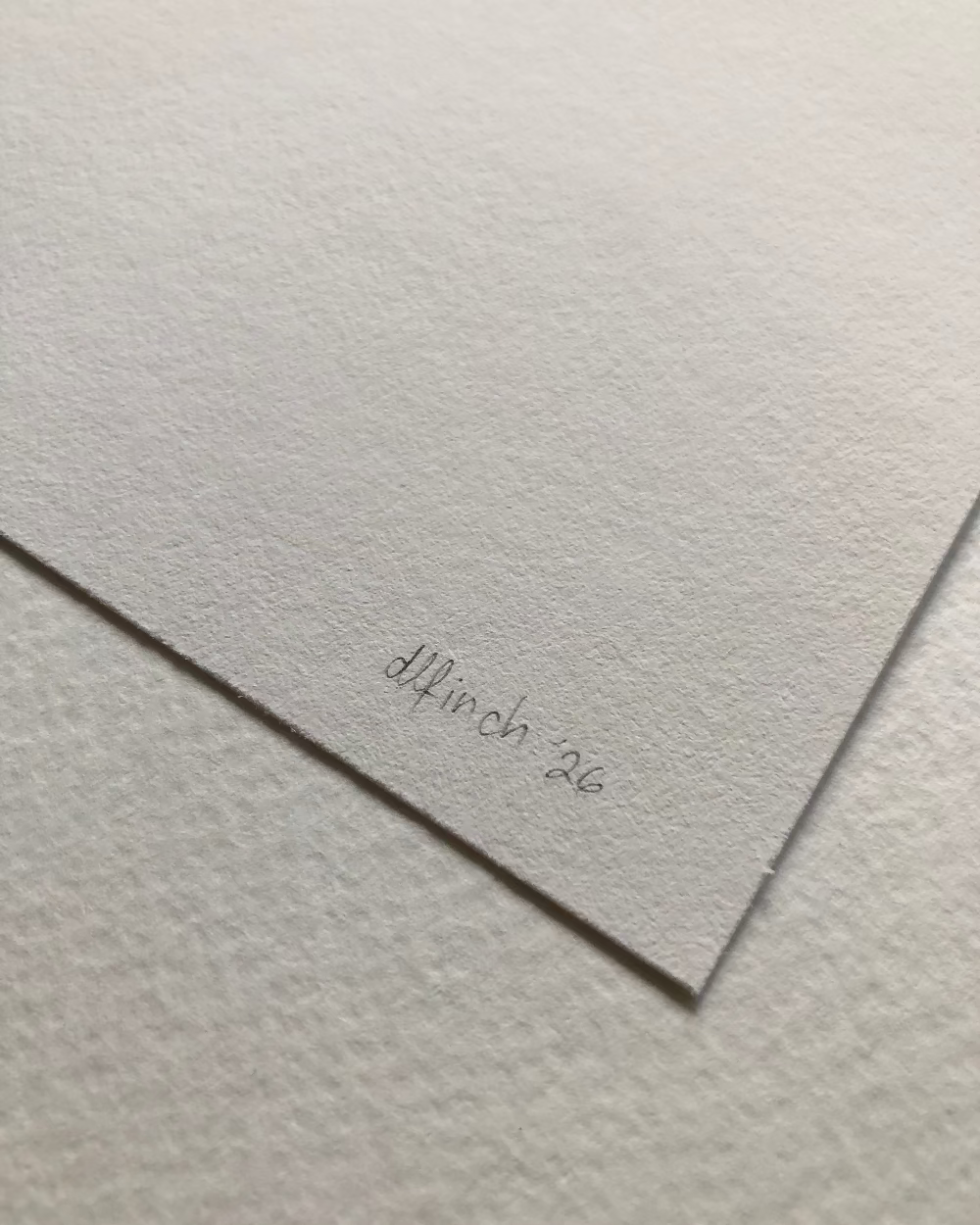 A close-up of textured white paper with a signature and date, 'dlfinch 26', written near the lower right corner.