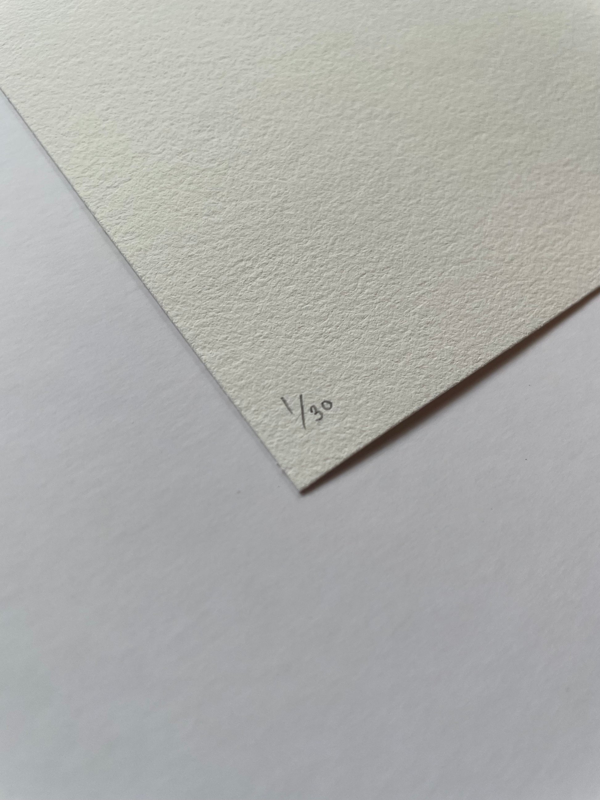 Textured white paper corner with '1/30' written on it