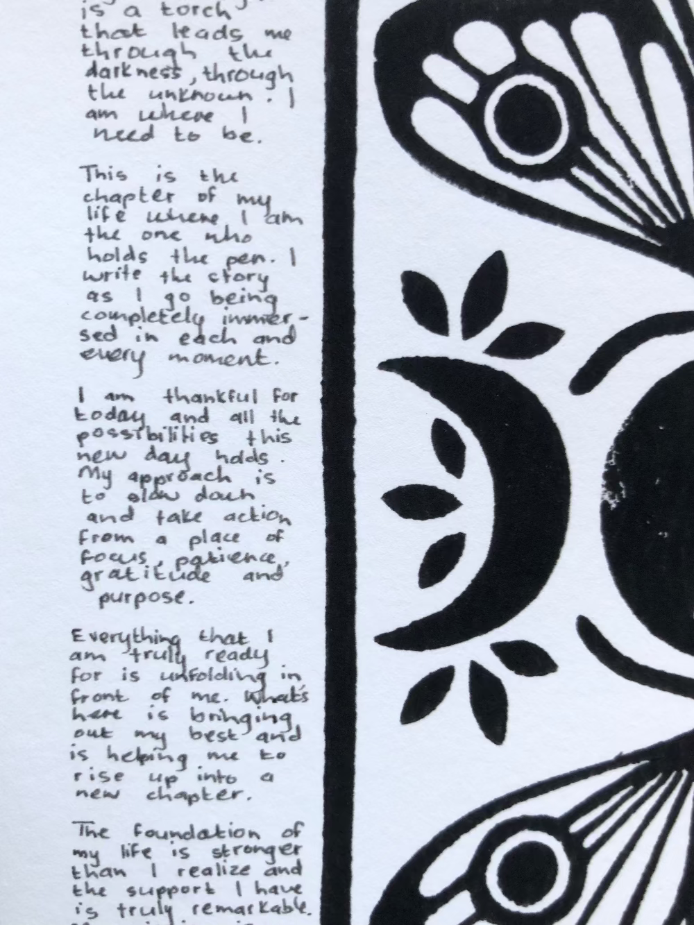 Close up of a lino print of moths and moons surrounded by tiny handwritten positive affirmations.