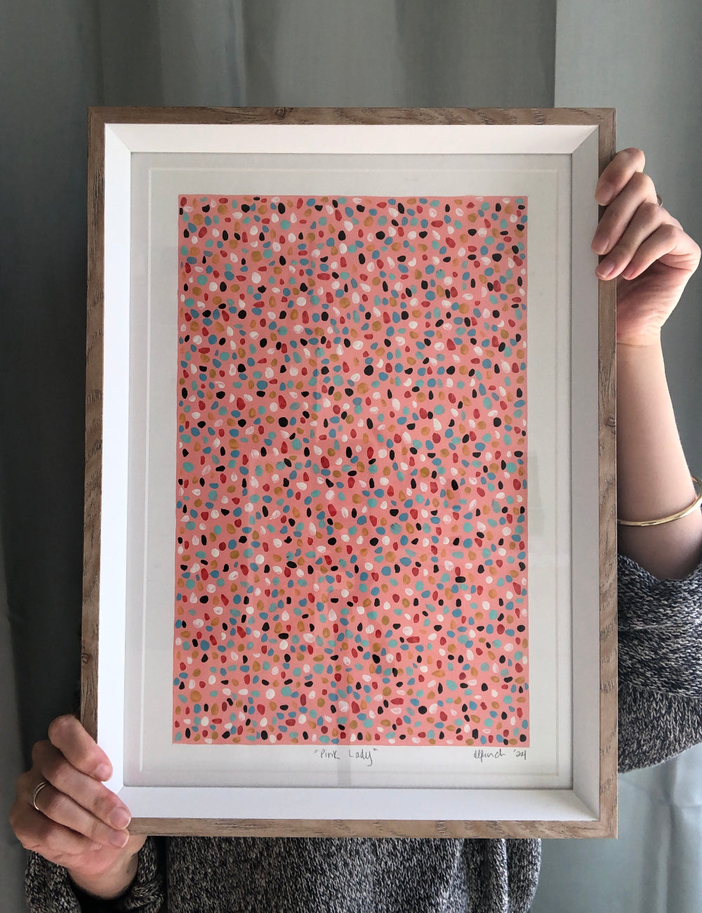 Gouache and acrylic mix abstract artwork with colourful dots held by artist for size reference.