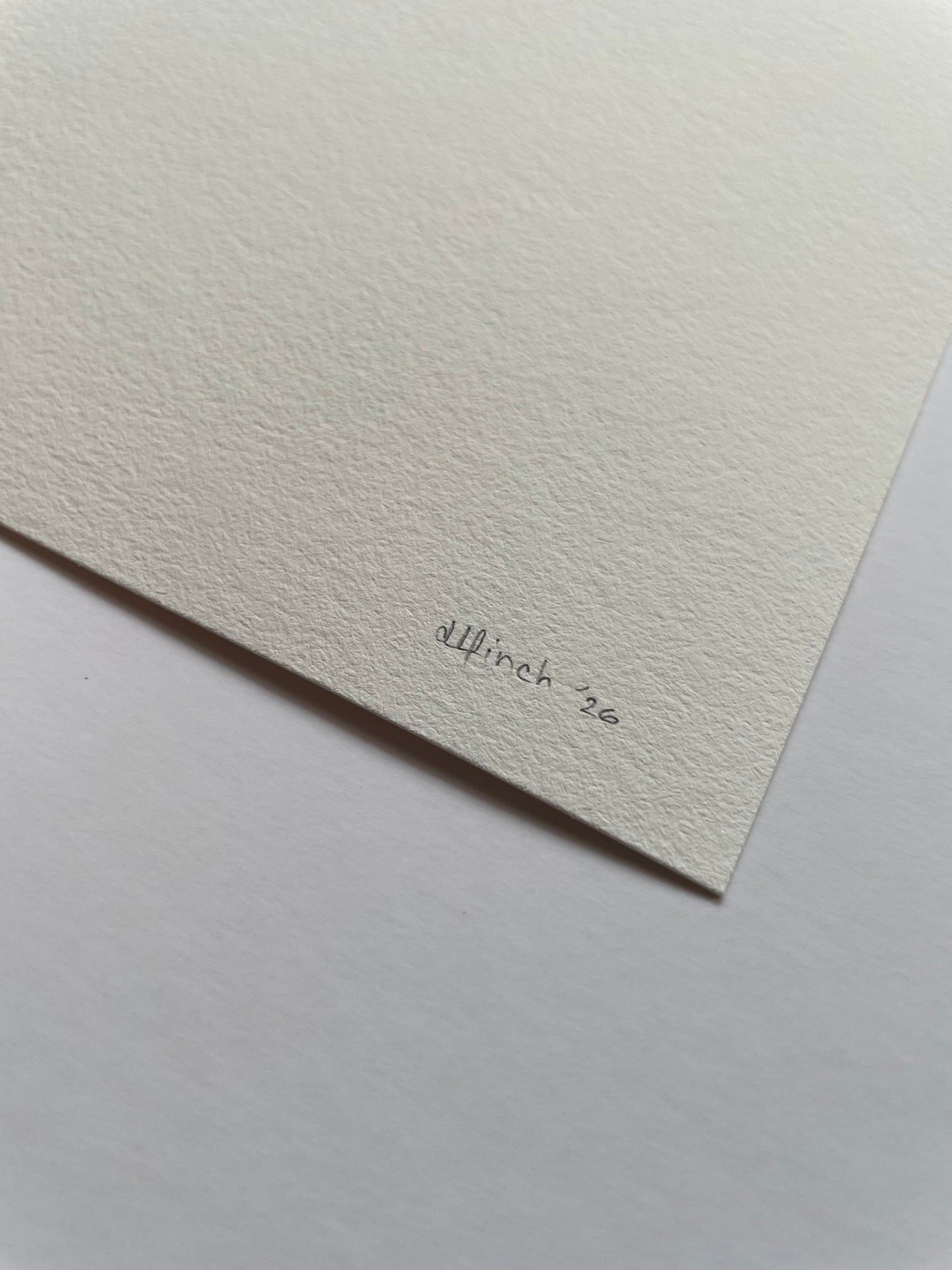 Corner of light textured paper with 'dlfinch '26' written on it