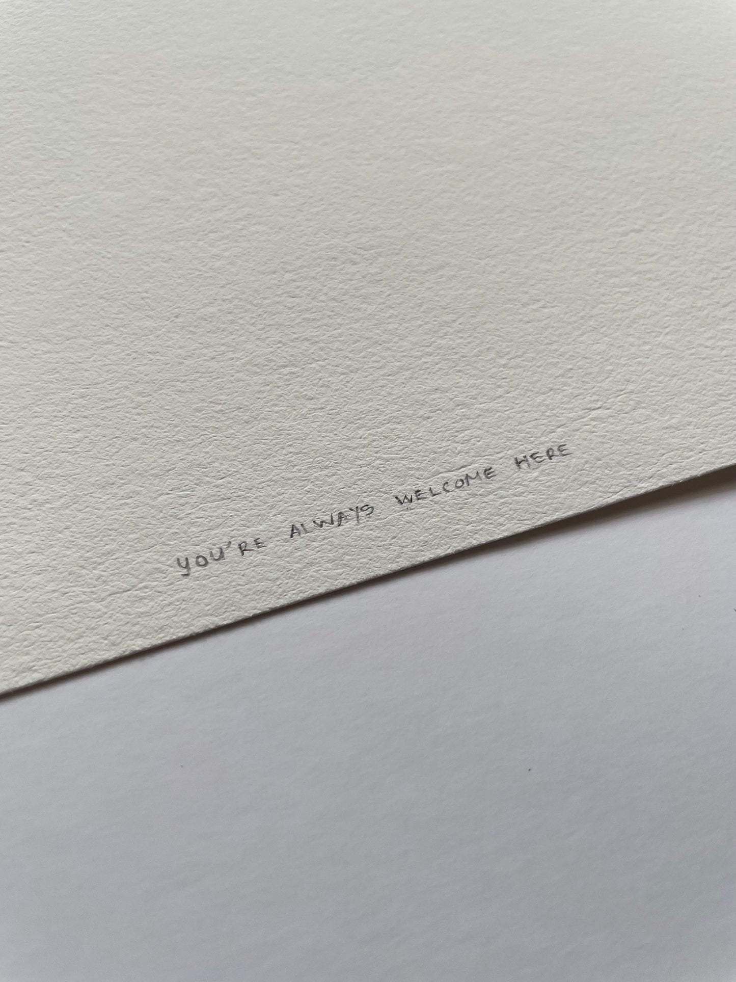 Light textured paper with 'You're always welcome here' written on it