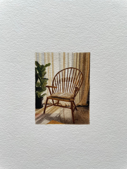 Wooden chair with a cushion in a room with curtains and a plant and sun filtering through