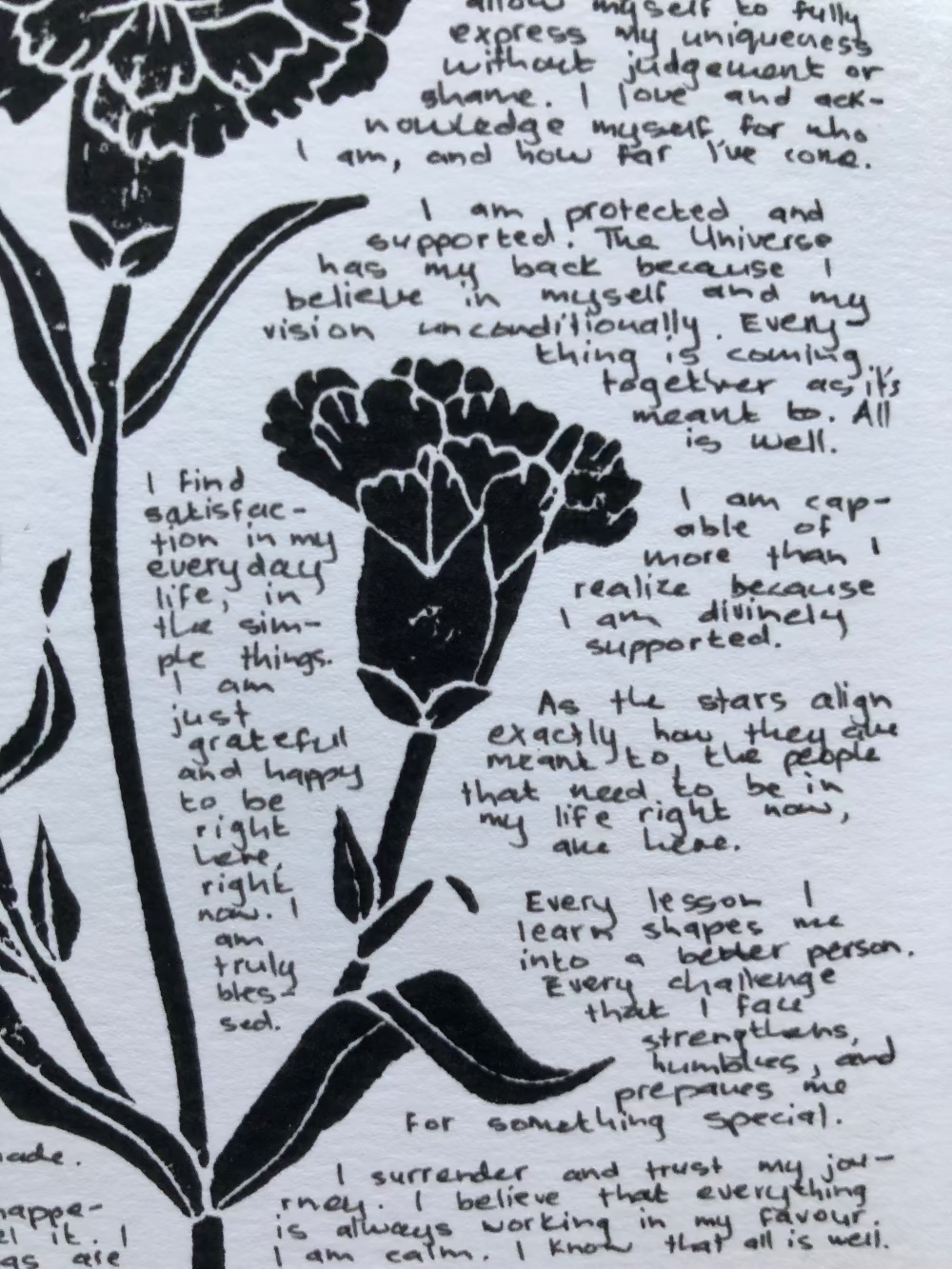 Close up of a lino print surrounded by tiny handwritten positive affirmations.