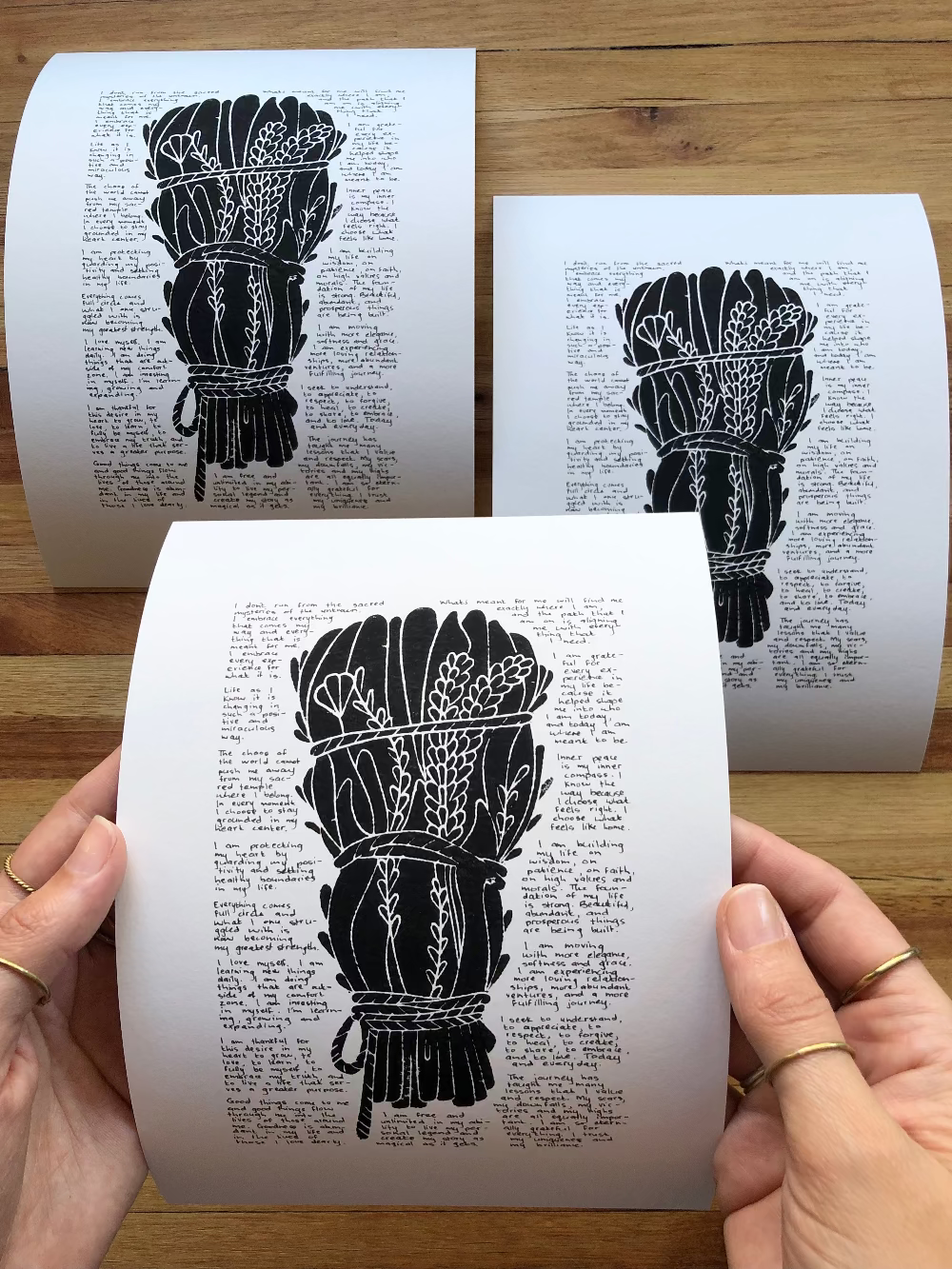 Three prints together on the table. One is being held to show perspective.