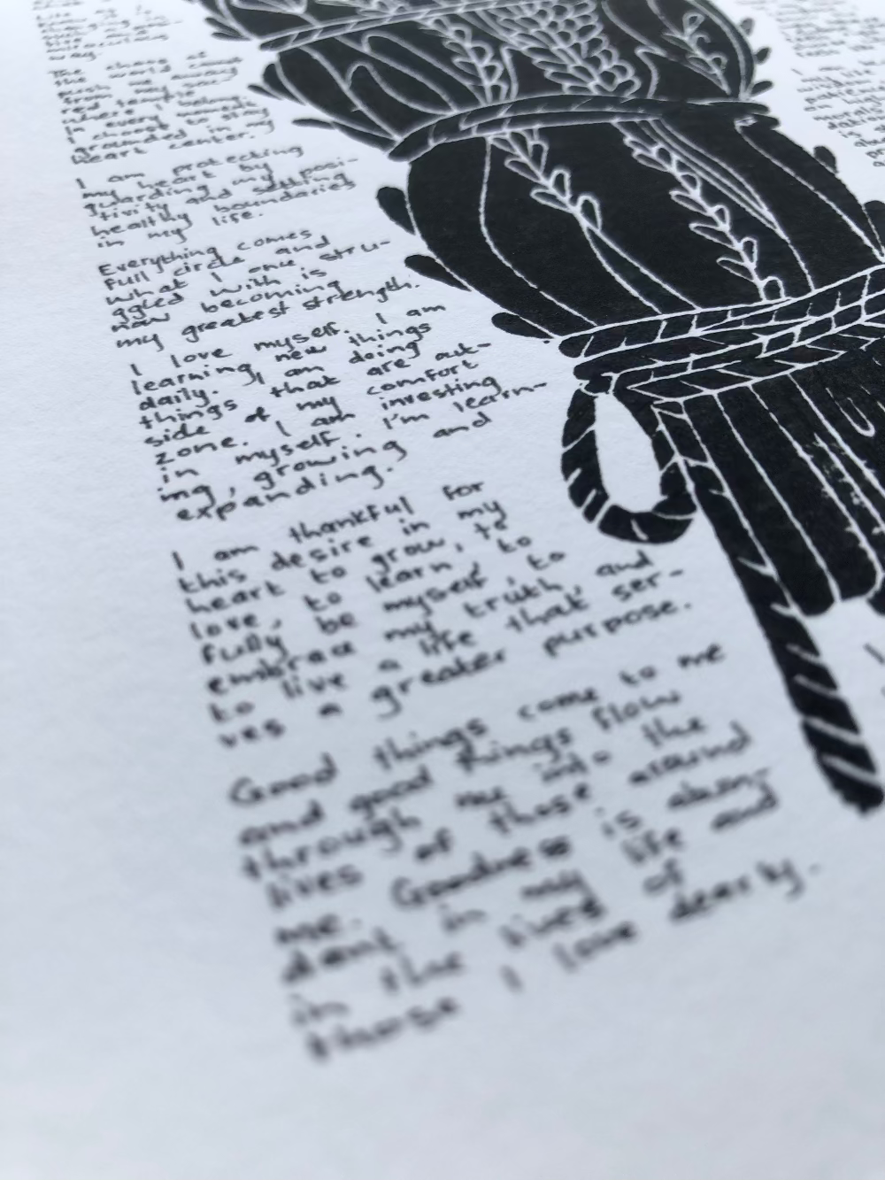 Close up of the written text in the foreground and the lino print in the background.